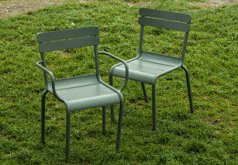 metal street chairs on green grass in the summer during the daytime