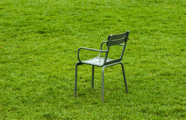 metal street chairs on green grass in the summer during the daytime