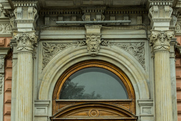 antique wooden frame with transparent glass on the facade of the building with a textured bas-relief