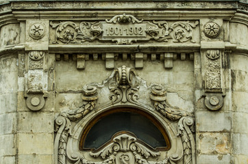 antique wooden frame with transparent glass on the facade of the building with a textured bas-relief