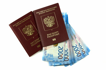 Two Russian passports with bills two thousand rubles on a white background. Traveling abroad, package trip, family.