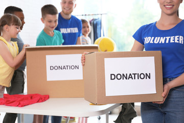 Volunteers with children sorting donation goods indoors