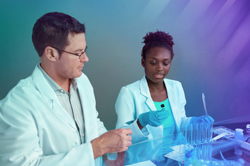 Scientists, senior Caucasian male and young African female, working together