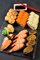 Sushi Set and sushi rolls served on stone plate
