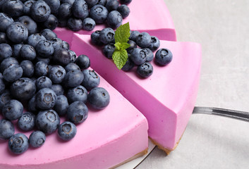 Cut tasty blueberry cake and shovel on light grey table, closeup