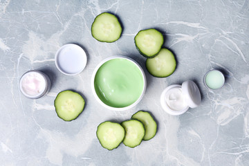 Flat lay composition with jars of body cream on grey marble background