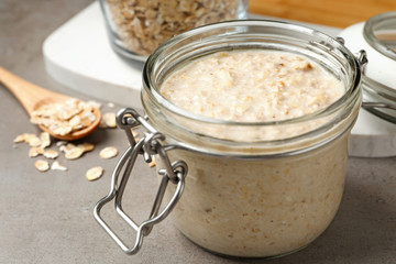 Handmade face mask and oatmeal on grey table