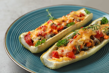 Delicious stuffed zucchini served on light grey table, closeup