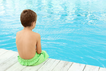 Fototapeta na wymiar Little child near outdoor swimming pool. Dangerous situation