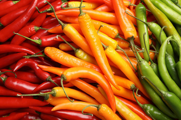 Different ripe chili peppers as background, top view