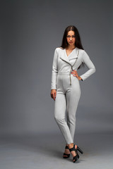 Sexy fashion brunette woman in gray leather suit