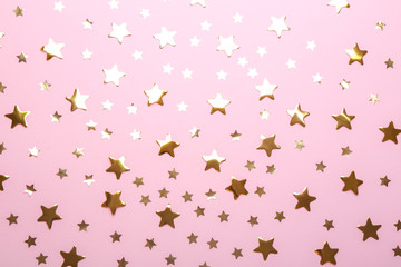 Confetti stars on pink background, flat lay. Christmas celebration