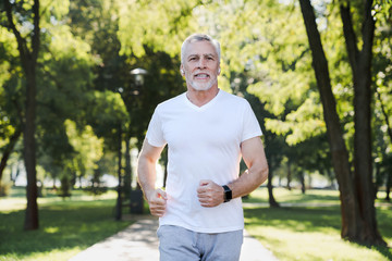Naklejka na ściany i meble Healthcare concept. Senior caucasian man jogging in a park