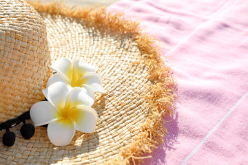Obraz na płótnie Canvas Straw hat and pink towel outdoors. Beach accessories