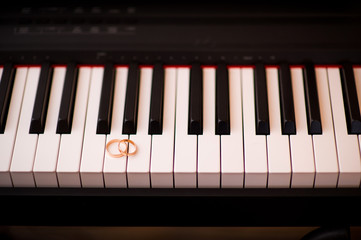 wedding rings on a piano keyboard