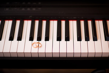 Fototapeta premium wedding rings on a piano keyboard