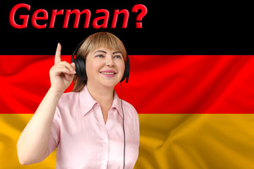 woman in headphones against the background of the national flag of Germany on delicate shiny silk,...