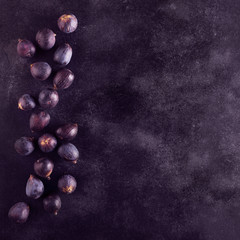 Fresh figs on a dark wood background, top view with copy space
