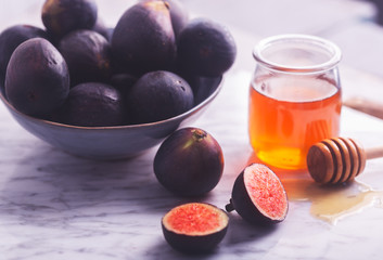 Fresh figs on a white stone background with honey