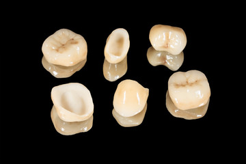 ceramic crowns of human teeth closeup macro isolate on a black background. The concept of aesthetic...