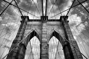 Abwaschbare Fototapete Malerischer Blick auf die architektonischen Details der Brooklyn Bridge in New York City in dramatischem Schwarz-Weiß-Monochrom unter stimmungsvollem bewölktem Himmel © lazyllama