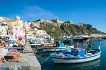 Fototapeta na wymiar Bright morning view of the picturesque Mediterranean village of Marina Corricella with brightly colored boats moored in the foreground on the island of Procida, Italy