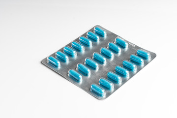 Blister with twenty-one blue tablets insulated on a white background. Diseases
