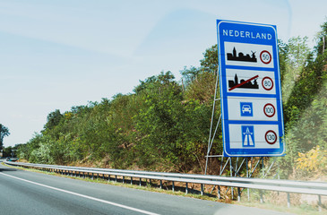Nederland text at the border between Germany and Netherlands with speed limits in city, highway and rural roads