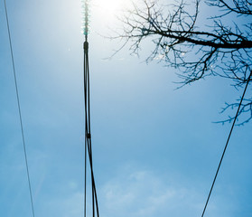 Low angle detail view of high voltage French power lines against blue sky background at the hydroelectric power plant at Centrale Hydroelectrique de Gambsheim