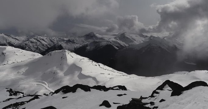 4K Time Lapse of Snow Covered Alpine Glacial Peaks Surrounded by Storm Clouds