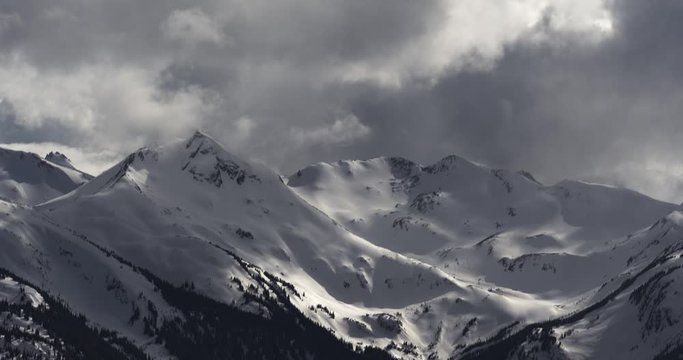 4K Time Lapse of Dramatic Snow Covered Alpine Peak Surrounded by Storm Clouds