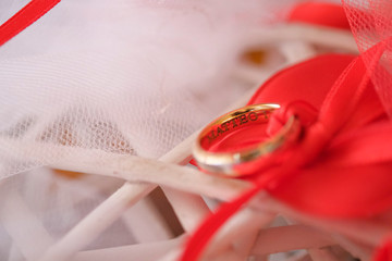 fedi per sposi su fiocchi rossi e bianchi oro