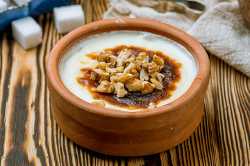 sutlac with nuts on wooden table. Turkish cuisine.