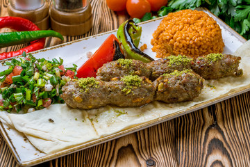 Lula kebab with pistachios Turkish cuisine on wooden table