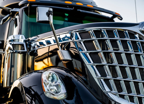 Professional stylish black big rig semi truck tractor with shiny chrome grille