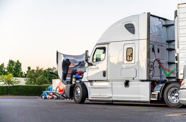 White big rig semi truck with open hood for engine inspection standing on the truck stop © vit