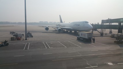 Passenger plane standing in airport on the concrete paved runway terminal