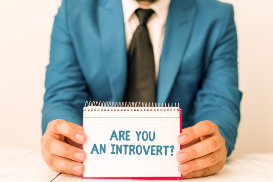 Word writing text Are You An Introvertquestion. Business photo showcasing demonstrating who tends to turn inward mentally Man holds empty paper with copy space in front of him Space