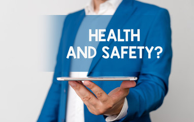 Handwriting text Health And Safety Question. Conceptual photo regulations and procedures to prevent accident or injury Man in the blue suite and white shirt holds mobile phone in the hand