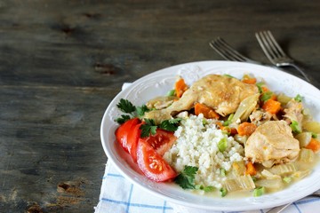 Chicken with Cauliflower Rice. low carbohydrates a lot of protein. stewed chicken with celery and carrots in a white plate. keto dish. 