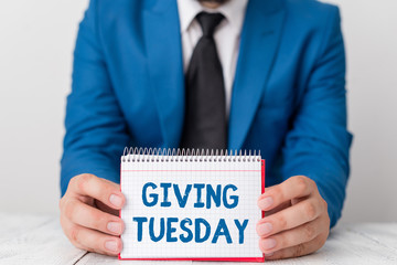 Word writing text Giving Tuesday. Business photo showcasing international day of charitable giving Hashtag activism Man holds empty paper with copy space in front of him Space