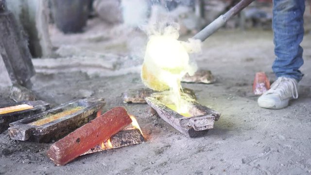 Artisan working gold melting process. Molted metal pouring into bar form.Solids that have undergone high heat treatment for melting according to the model.4k Resolution.