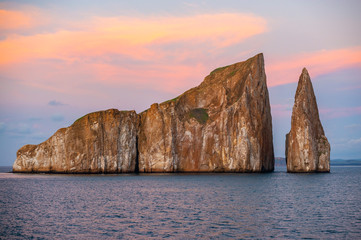 The volcanic rock formation of Kicker Rock (Leon Dormido) at sunset in the Pacific Ocean with sea...