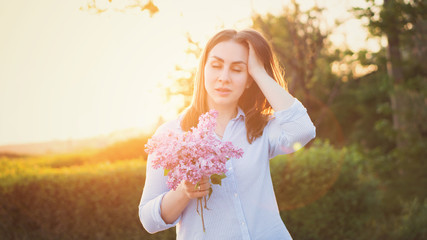 Sensuous hipster girl standing in park in evening sunshine. Stylish woman traveler in spring...