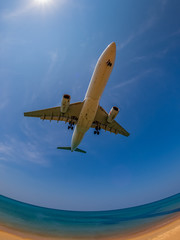 Landing airplane near by sea. blue sky, clear water, amazing view