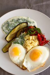 breakfast of fried eggs vegetables and  yogurt