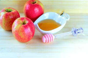 Jewish holiday Rosh Hashana background with honey and apple on wooden table. During the Jewish New Year Rosh Hashanah customary eat sliced apples dipped in honey symbol sweet new year.
