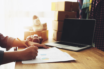 Women hand pointing graph financial business document with on home office table, Online selling e-commerce shipping idea concept freelance start up small business owner