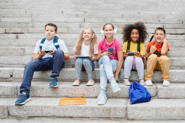 Obraz premium Group of school kids sitting on school steps