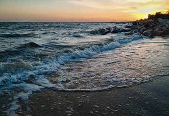 Beautiful sunset and sea view. Waves, foam and coastline.